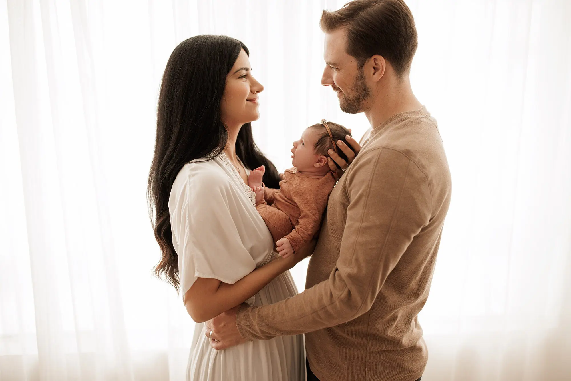 Which type of newborn photo session is best - mom and dad holding baby in front of white windows