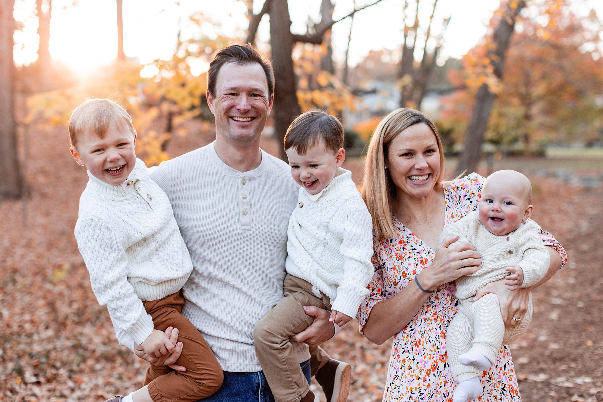 Boston Fall Family Photos - family of 5 standing in the woods laughing and smiling with fall foliage