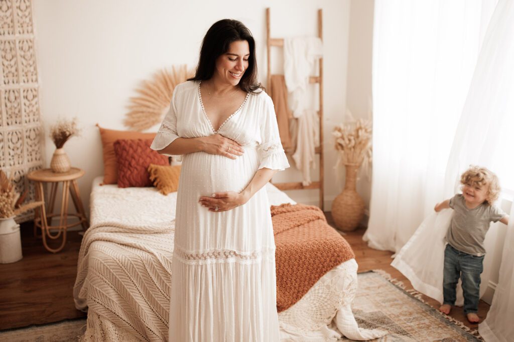 what to wear for your maternity photo session - little boy looking at gorgeous mama in white dress
