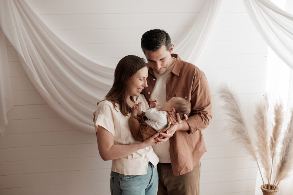 Is my baby too old for newborn photos - mom and dad looking at baby in mom's arms
