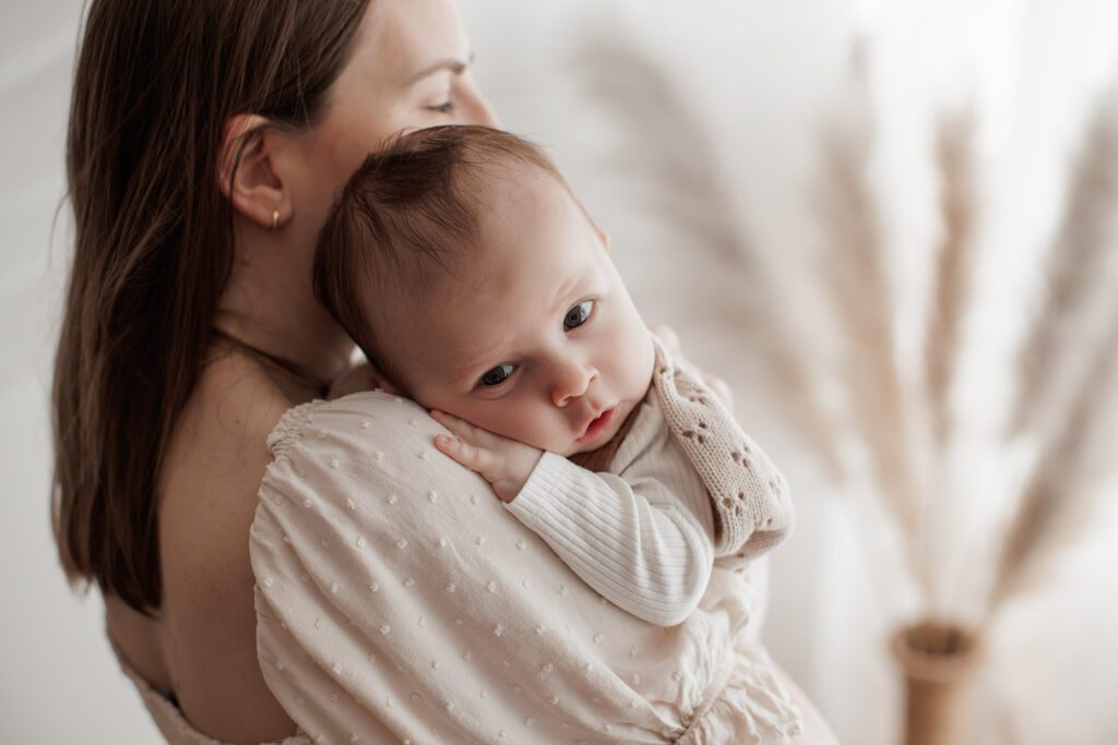 Is my baby too old for newborn photos - baby on mom's shoulder snuggling