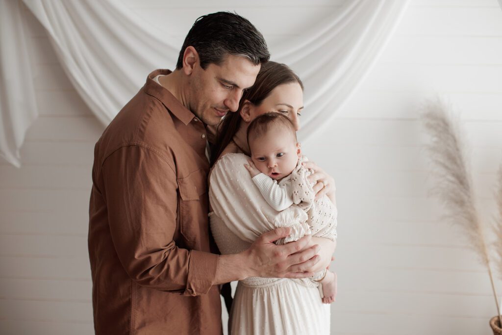Is my baby too old for newborn photos - mom and dad snuggling with baby