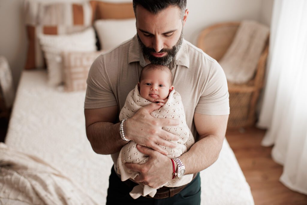 studio lifestyle newborn photography - dad holding baby in his arms