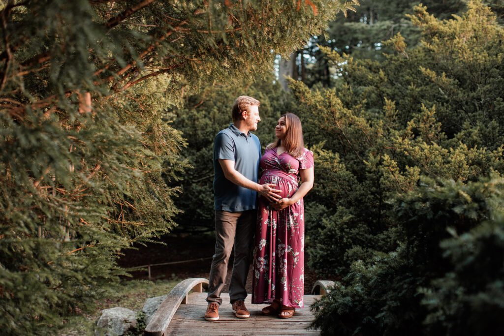 How to prepare for postpartum - expecting parents looking at each other during a maternity photography session in Boston MA