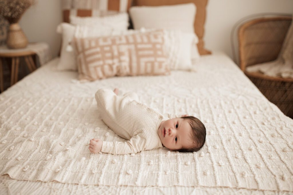 Boston newborn portraits - baby laying on bed