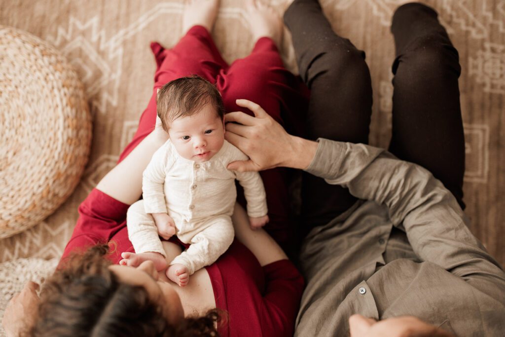 Boston newborn portraits - baby from above laying in parents lap