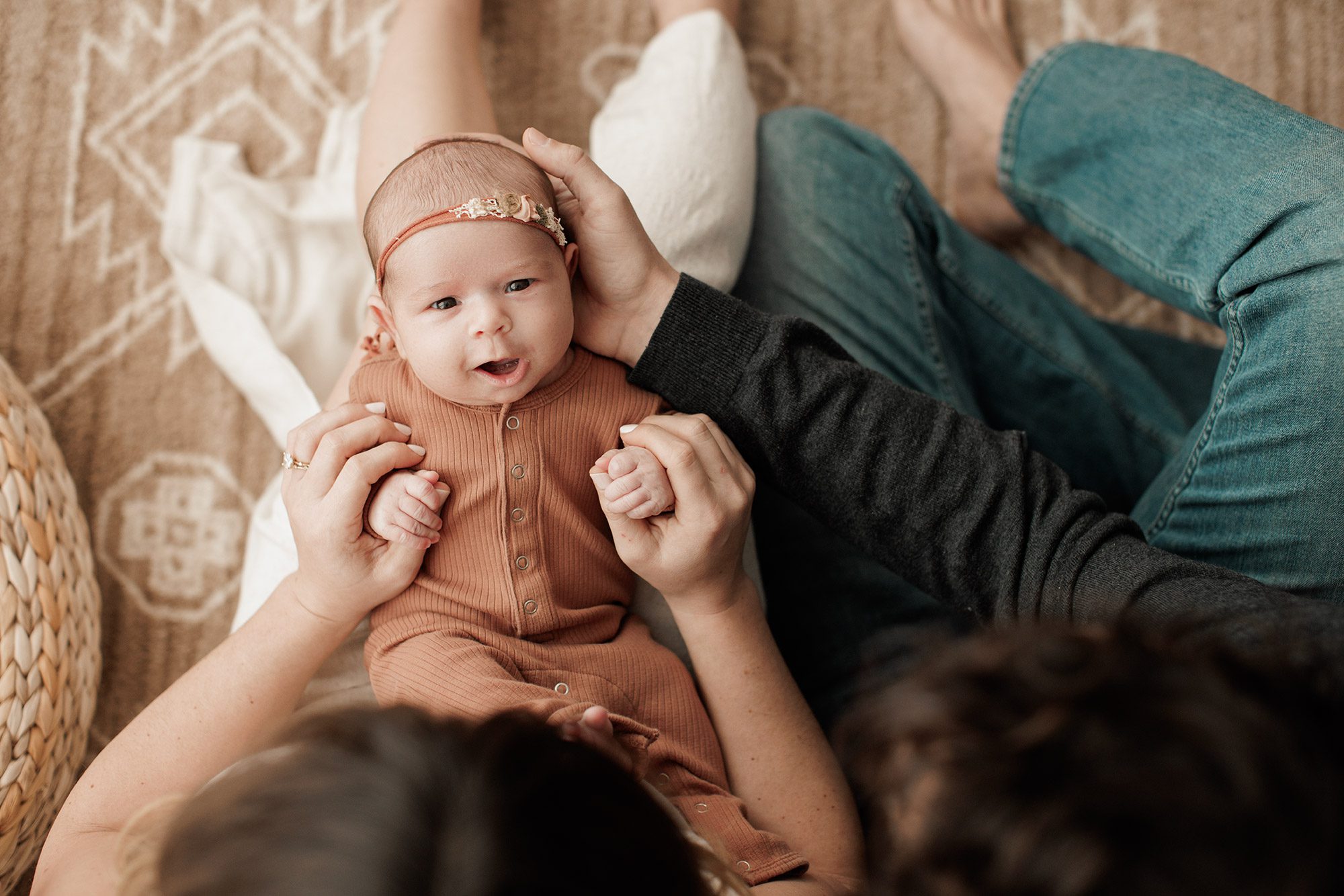 Favorite Newborn Photography Poses - baby girl laying in parents lap smiling