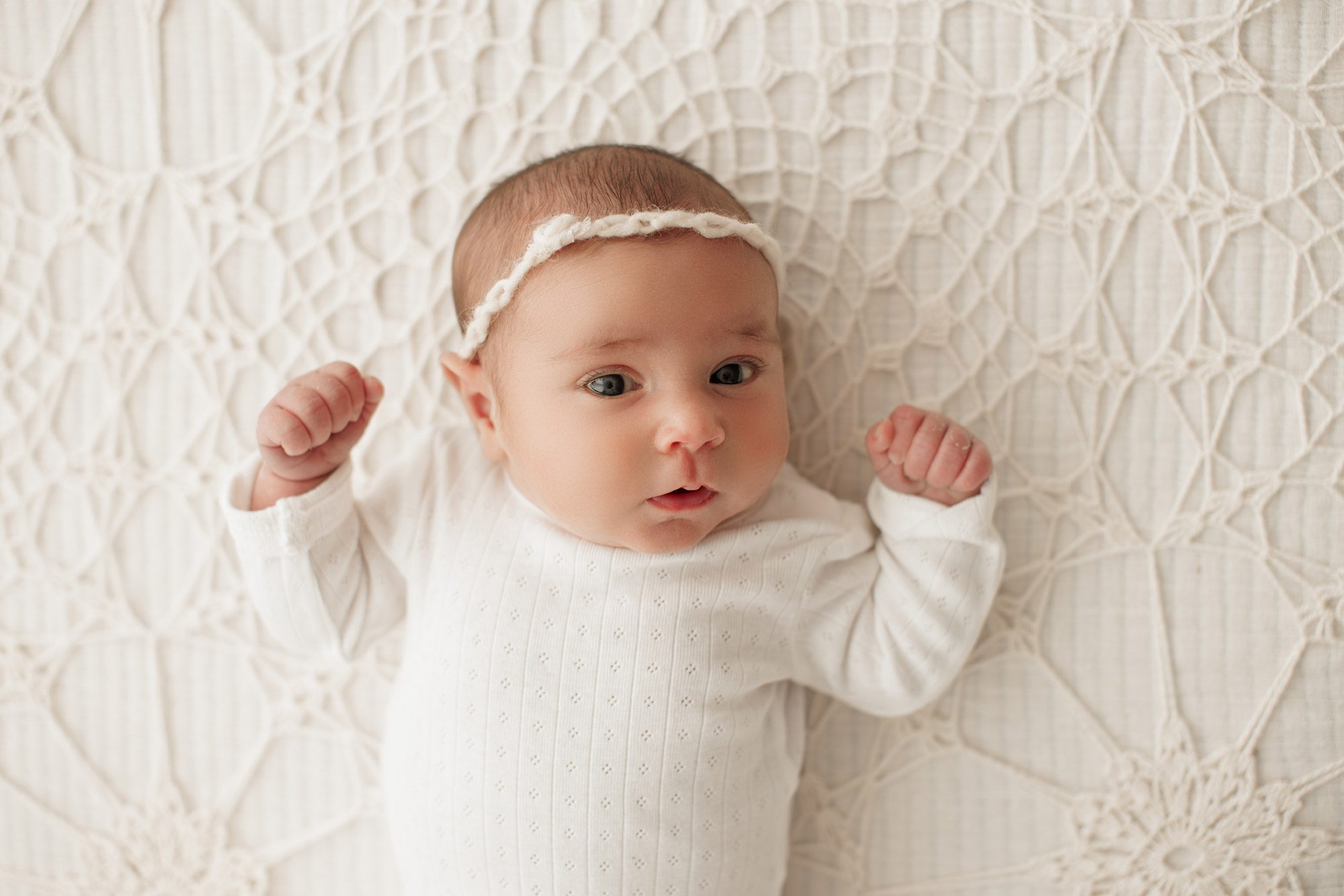 cozy minimalist newborn photoshoot Boston - baby laying on a bed