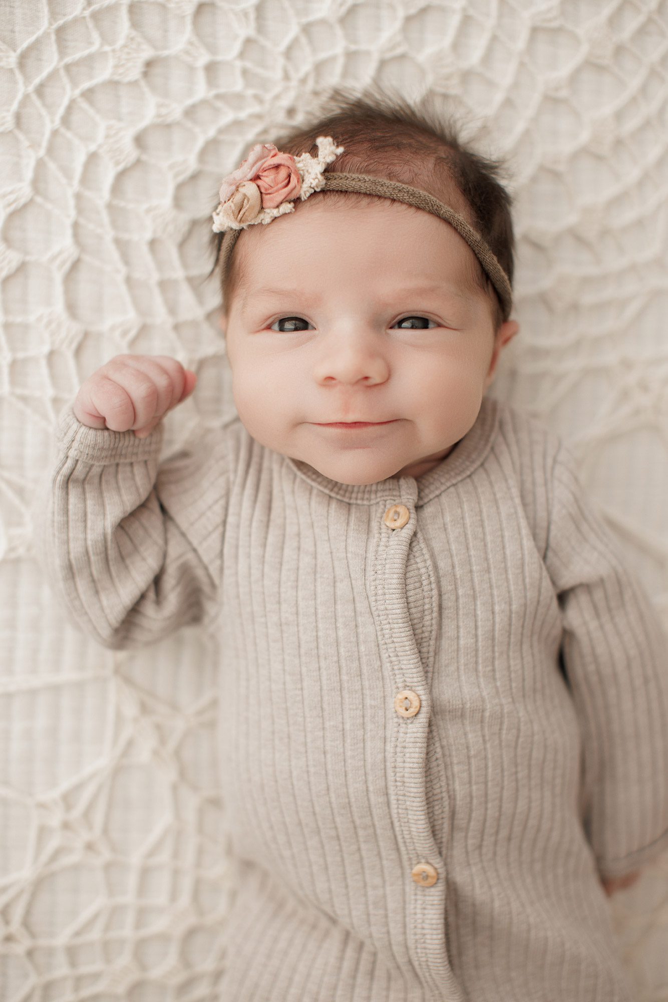 Best Location for a Newborn Photoshoot - baby girl laying on a cream lace bed in neutral outfit