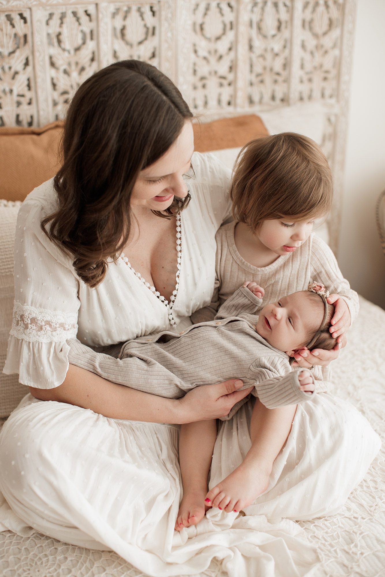Best Location for a Newborn Photoshoot - mom and sister looking at baby