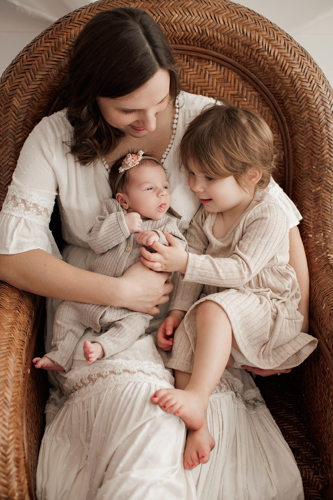 Best Location for a Newborn Photoshoot - mom in a chair with baby and toddler