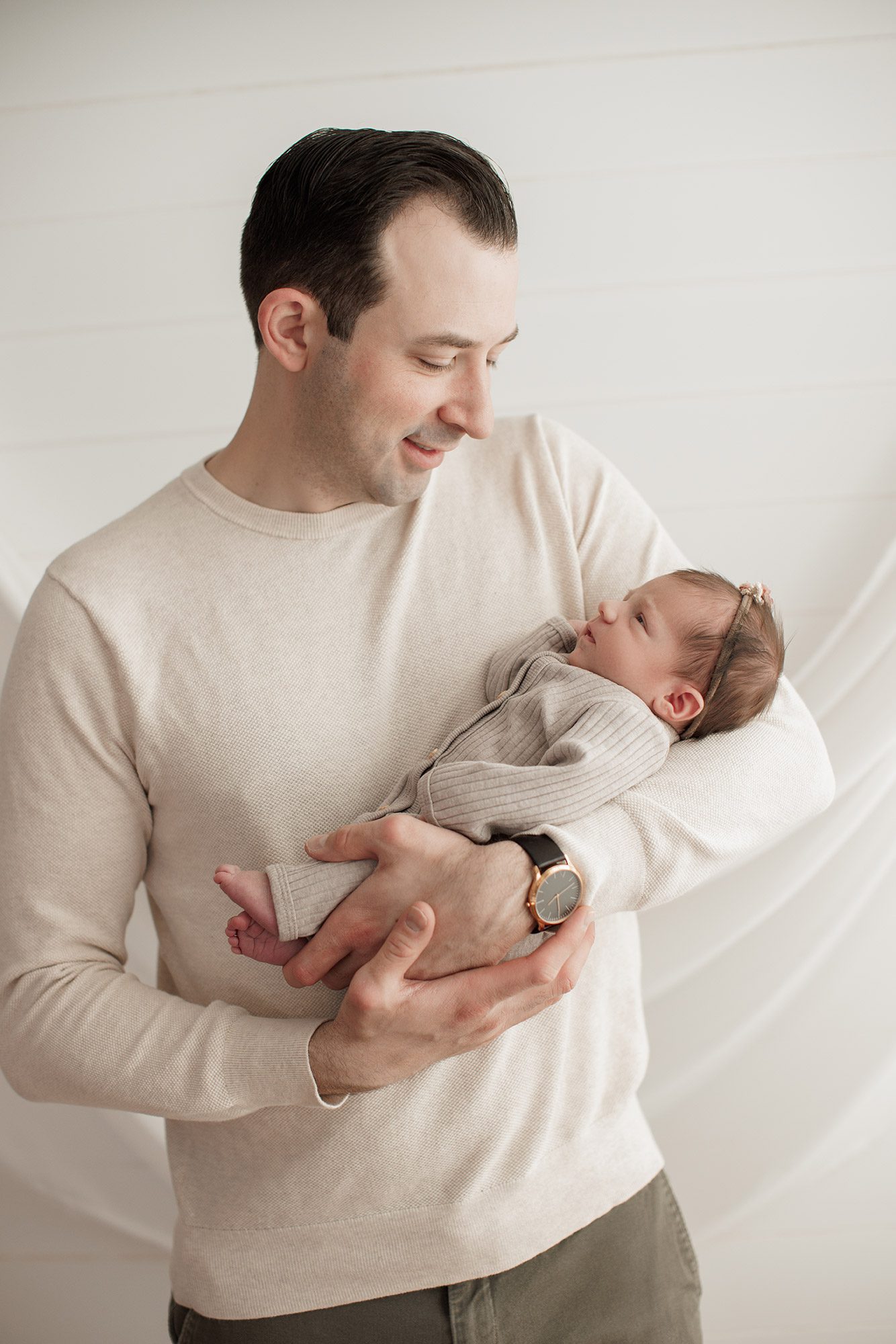 Best Location for a Newborn Photoshoot - dad wearing cream shirt with cream background