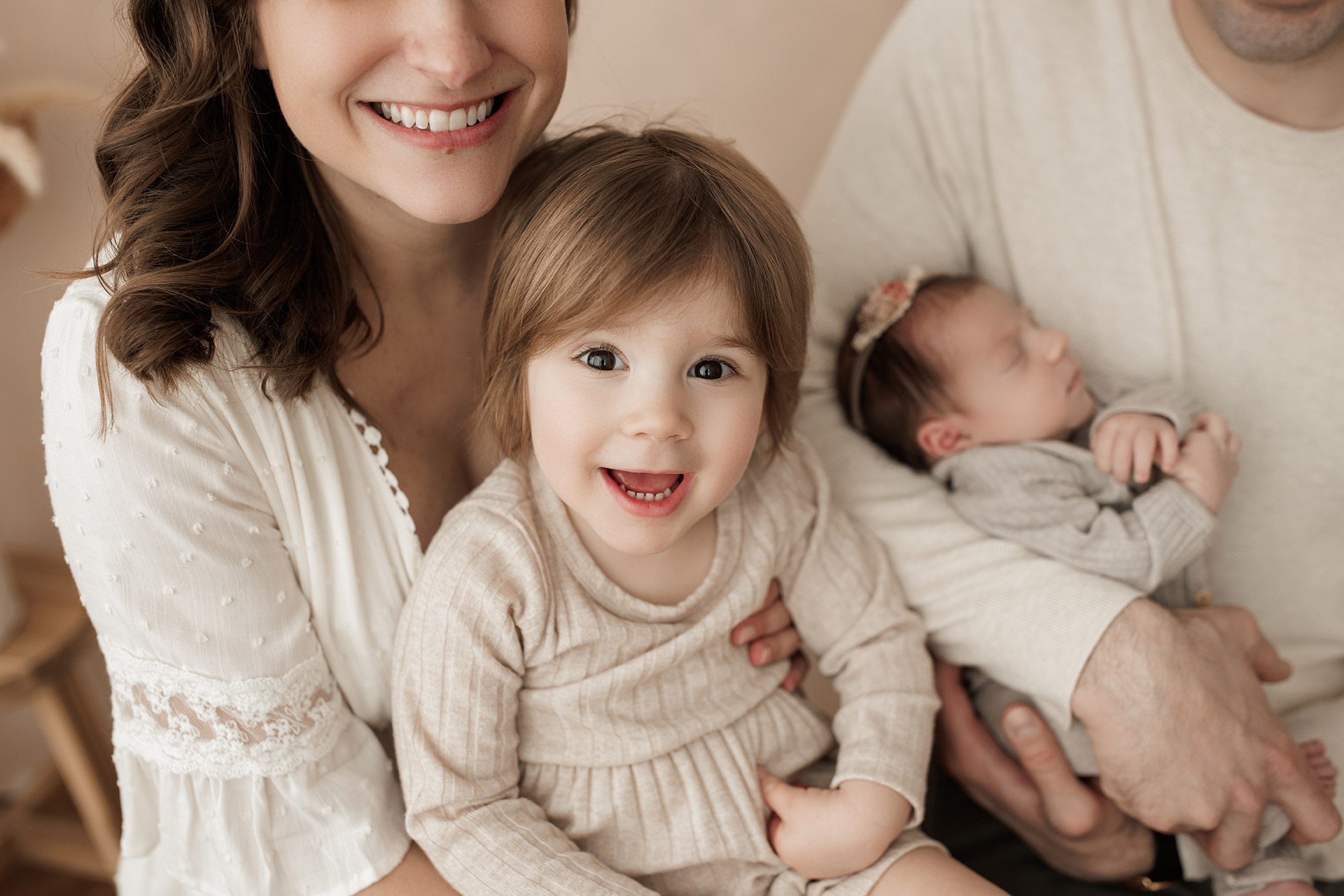 Best Location for a Newborn Photoshoot - big sister smiling on mom's lap
