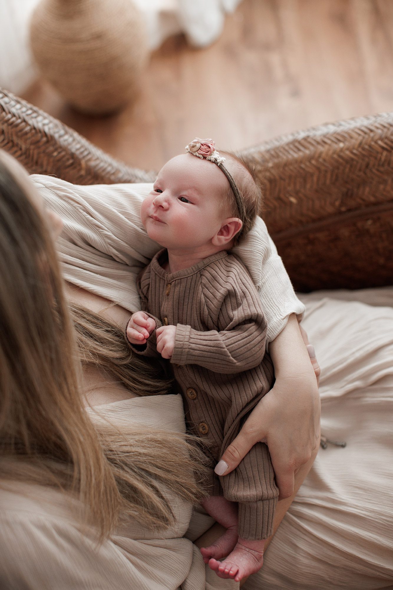 How to choose the right newborn photographer for your family - baby girl laying in mom's lap